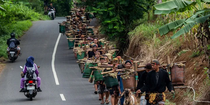 Puluhan komunitas adat Bonokeling membawa hasil bumi pada saat prosesi Unggah-unggahan