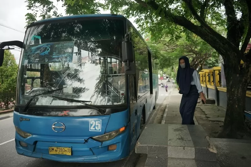 Pelajar menaiki Bus Trans Metro Pekanbaru di Halte SMPN 14 Jalan Hang Tuah Pekanbaru, Selasa (11/3/2025). Mulai kemarin pemko menggratiskan tarif bus TMP bagi pelajar se kota Pekanbaru. (EVAN GUNANZAR/RIAUPOS.CO)