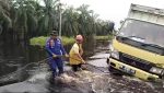 Dua Perwira Bantu Tarik Mobil Box Terperosok di Lokasi Banjir Pelalawan